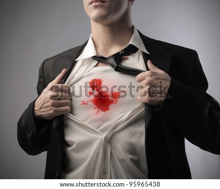 Businessman showing the blood stain on the vest under his shirt