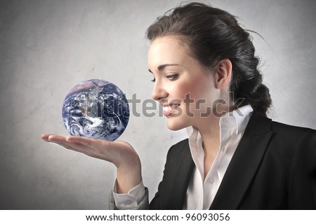 Smiling businesswoman holding the Earth in her hand \
