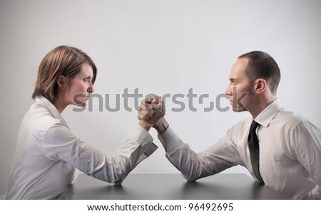 Couple of business people playing arm wrestling