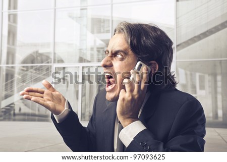 Angry businessman screaming on the mobile phone