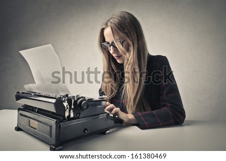 beautiful woman writing with a vintage typewriter