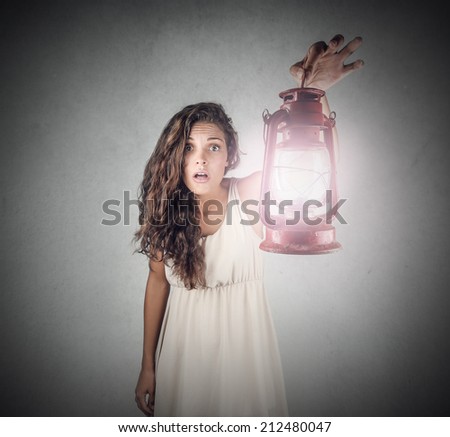 dark haired girl wearing a white dress and holding a lantern