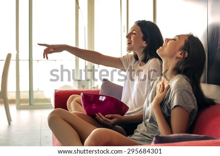 Two girls watching tv together