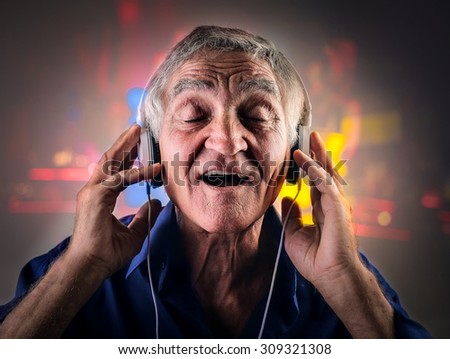 Elderly man listening to music through a pair of headphones