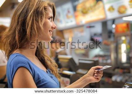 Young woman paying at a fast food restaurant