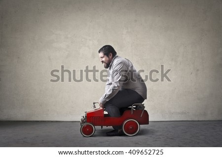 Chubby man driving toy car
