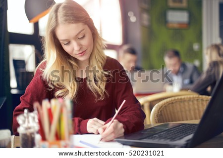 Blonde girl writing in notebook