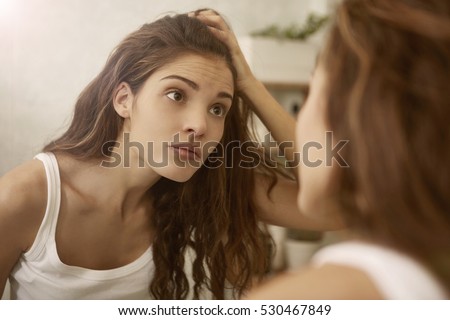 Girl looking herself in the mirror