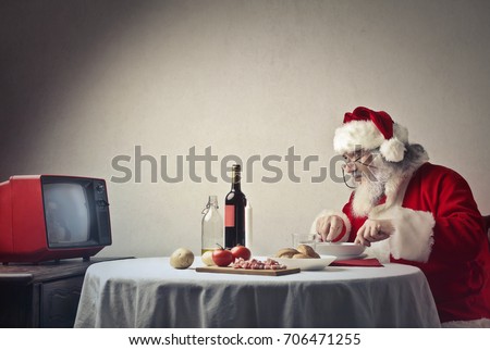 Santa Claus having dinner in front of the tv