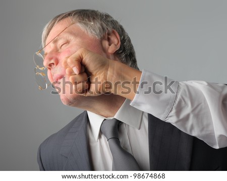 Senior businessman being punched in the face