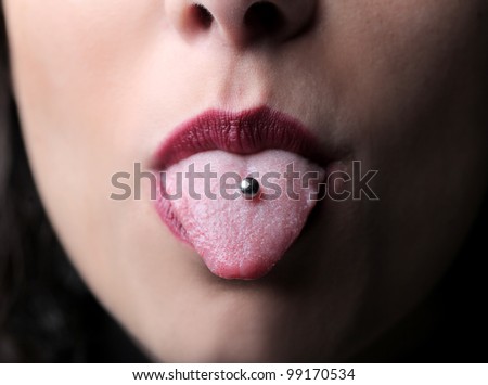 Closeup of a woman\'s tongue with a piercing
