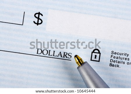 A closeup of a bank check with a pen.