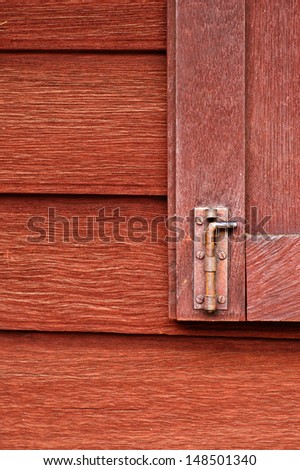 red wooden old wall and windows lock in old house Lopburi province of Thailand