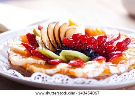 Delicious Fruit Tart. View of a delicious Fruit Tart placed in a dish on a wooden table