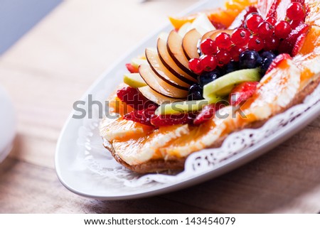 Delicious Fruit Tart. View of a delicious Fruit Tart placed in a dish on a wooden table