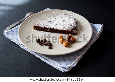 slice of chocolate cake with hazelnut and coffee, powdered sugar
