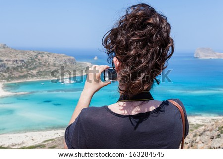 Balos beach, Crete, Greece, Tourist taking a picture with your mobile phone