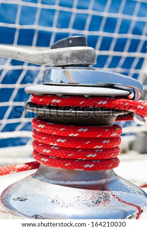 Winch of a sailboat, detail of a red rope during a sailing