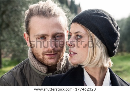 Portrait. Young blond man in a park and a girl with blond hair