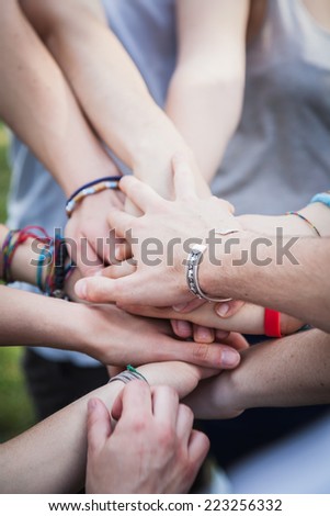 Teamwork, pile of hands of people to the park.