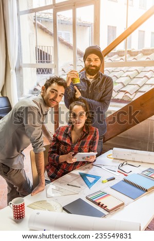 Teamwork. Three young architects working on a project at a table in the study