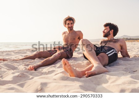 Portrait. Couple of male friends at sunset on the beach on a day of rest summer vacation together, after spending a day of relaxation and fun.
