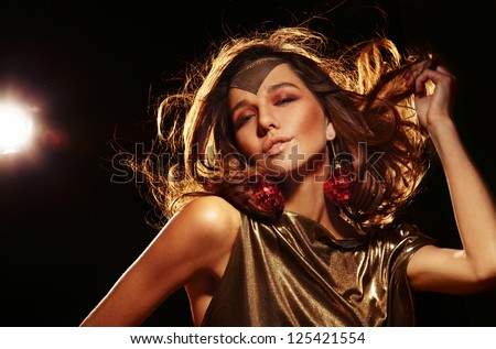 beautiful exotic tanned woman with long wavy hair in motion studio shot darker tones