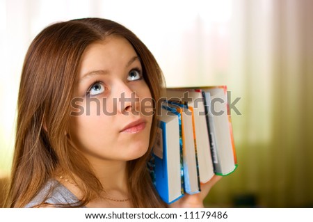 Beautiful young female student carrying books 2