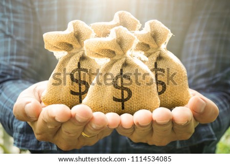 Money bags in man hand show savings money and savings to buy a home or buy real estate or car. Or show a home loan or divide the investment for retirement. Or for the future Concept of money.