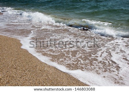 Sea waves run over on the shore and leave a trail of foams