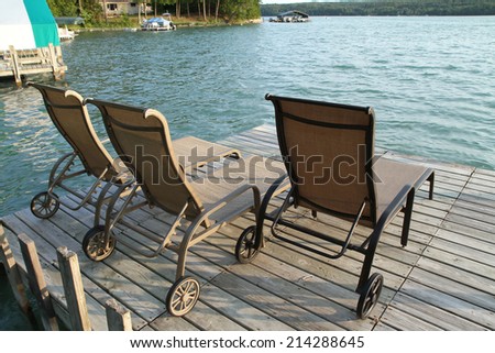 Lounge chairs on a beautiful lake front dock.