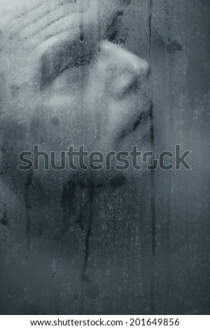 Portrait of man through wet glass