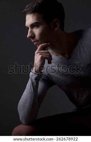 Young adult man in side lighting dark portrait