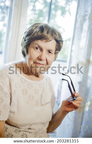 the old woman smiling and holding glasses