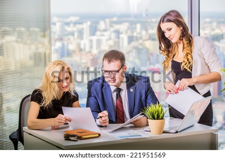 A business team of three in office and planning work
