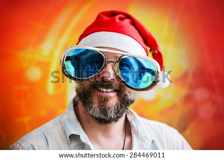 man with fashionable big beard in costume of Santa Claus and the big funny sunglasses