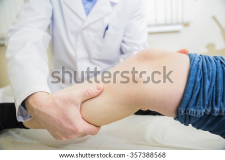 closeup doctor the traumatologist examines the patient the patient\'s leg