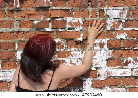 woman pressed against the brick wall and touched her hand