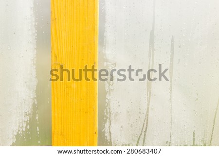 Cellophane misted, the wall of the greenhouse, wooden board background