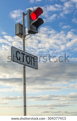 Red traffic stop sign against cloudy blue sky