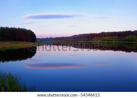 Sunset on a lake with cloud reflected in water
