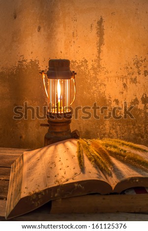 vintage still life with old books and burning candle