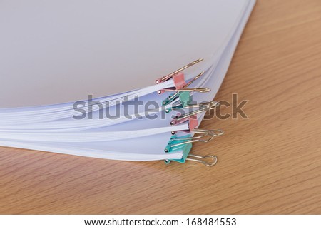 stack  of  white paper with clip on wood table