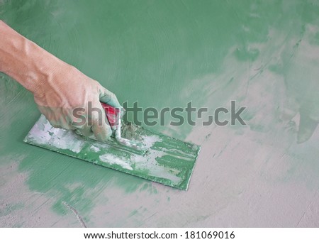 Workers  hand plastering color combination  a floor  with trowel. Construction worker. Masonry tool. Construction industry. Selective focus.