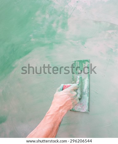 Workers hand plastering color combination a floor with trowel. Construction worker. Masonry tool. Construction industry. Selective focus.