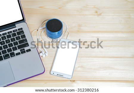 laptop,mobile phone,Bluetooth speakers, earphones on wood background