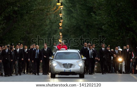 ROME, ITALY - MAY 07 - Pope Benedict XVI waves to pilgrims in his car, escorted by bodyguards, on his way to St. Mary Major Basilica in Rome, Italy on May 7, 2005.