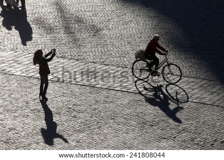 ROME, ITALY - JANUARY 2015, 05: Silhouette people enjoy the warm temperatures in Piazza del Popolo. After days of unusual cold the sun shines back in Rome and temperatures are back to the average.