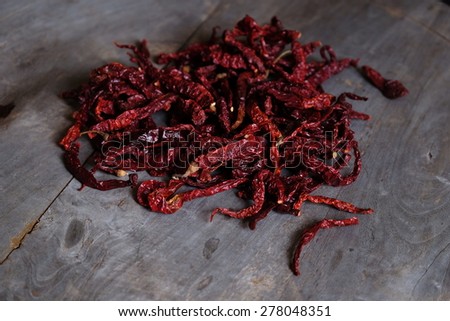 Dried red chili peppers on wooden table