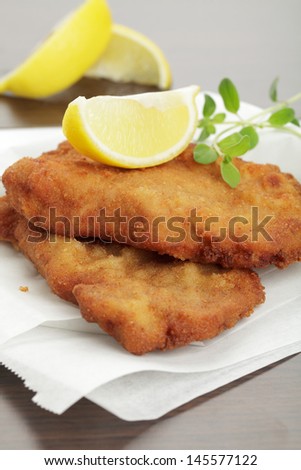 Breaded cutlet with lemon wedges